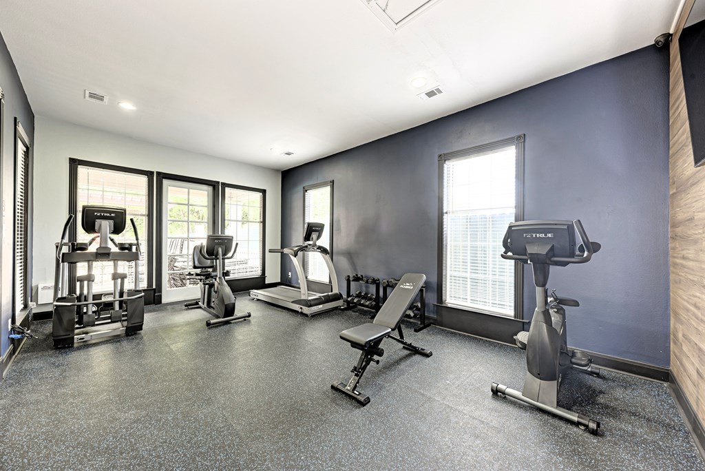 A room with a bookshelf, two chairs, a desk, and a computer.
