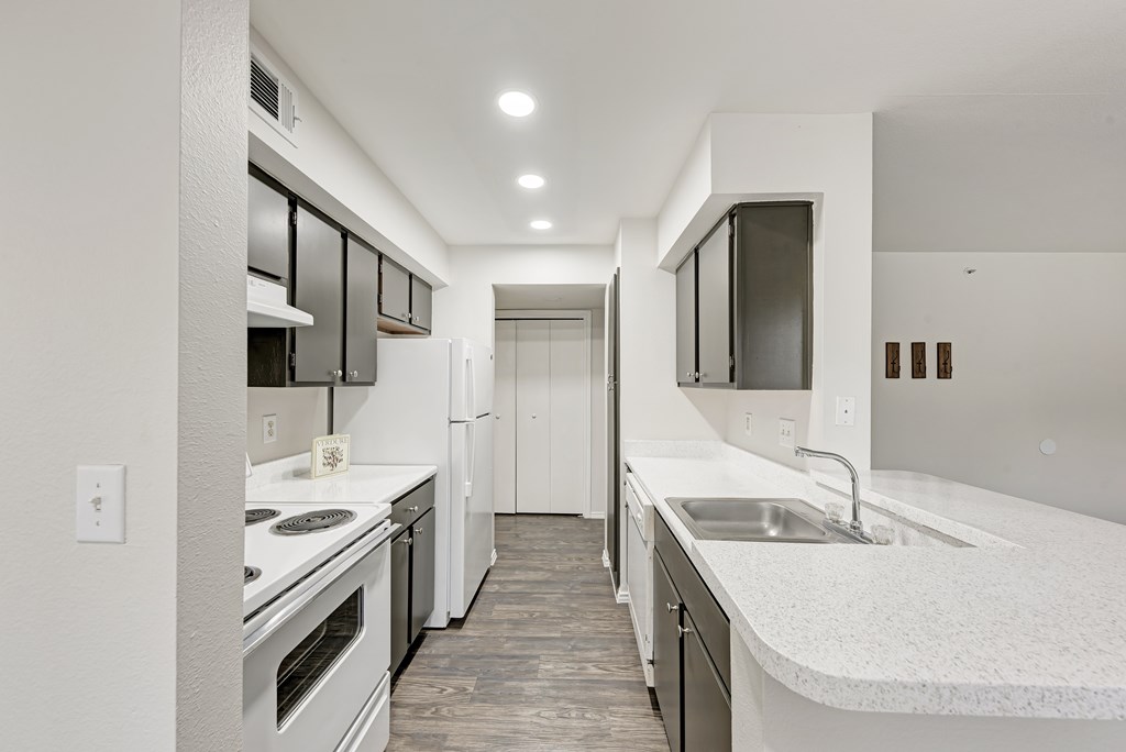 A kitchen with wooden cabinets and white appliances.