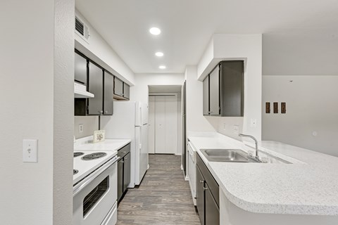 A kitchen with white appliances and wooden cabinets.