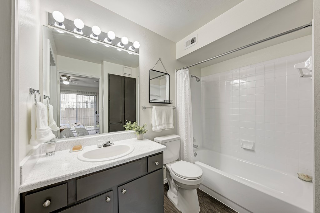 A bathroom with a sink, mirror, and towel rack.