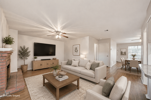 A living room with a fireplace and a flat screen TV.