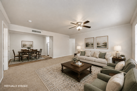 A living room with a brown coffee table and a white couch.