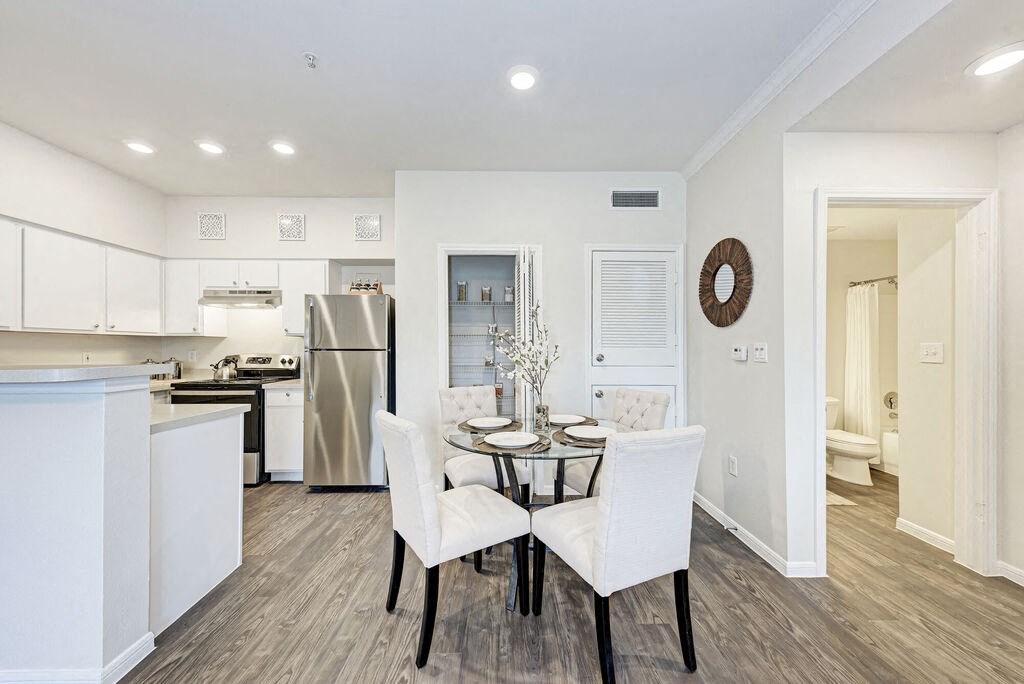 A modern kitchen with a dining table set for two.