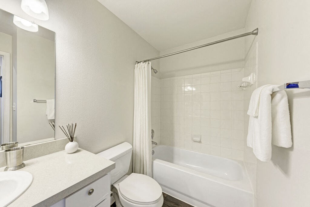 A white bathroom with a toilet, sink, and bathtub.