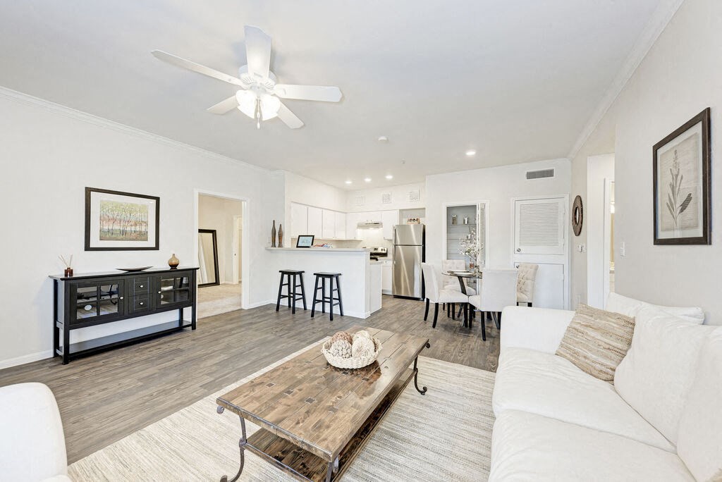 A modern living room with a white couch and a wooden coffee table.