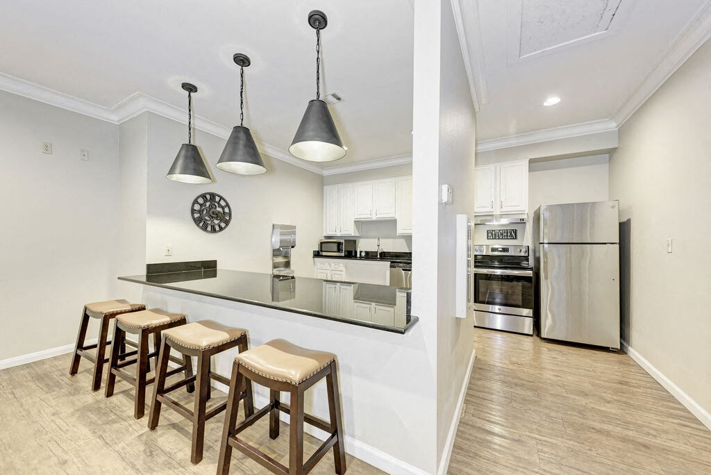 A kitchen with a bar area and stools.