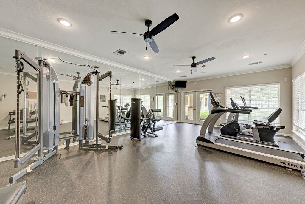 A spacious gym with a variety of equipment including treadmills, weights, and exercise machines.
