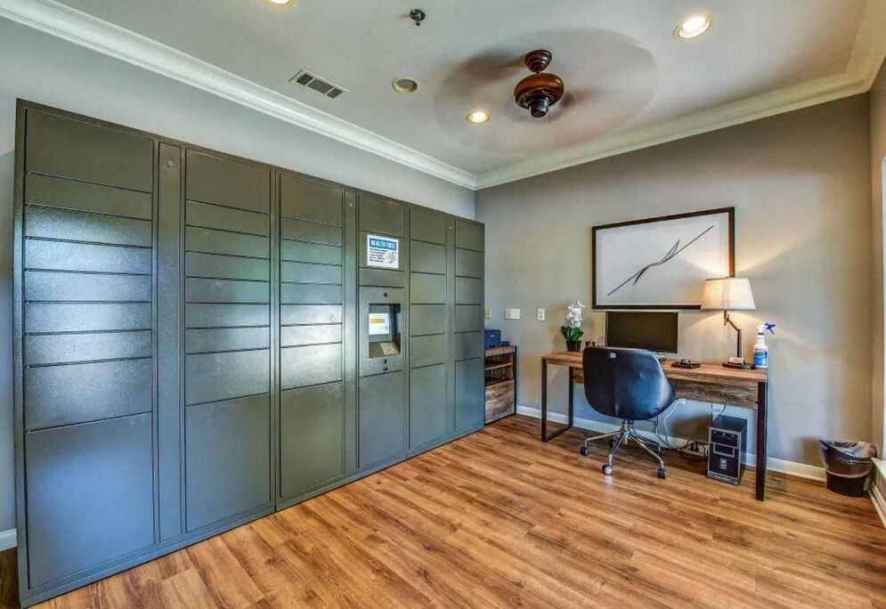 A room with a desk, chair, and a large glass door.