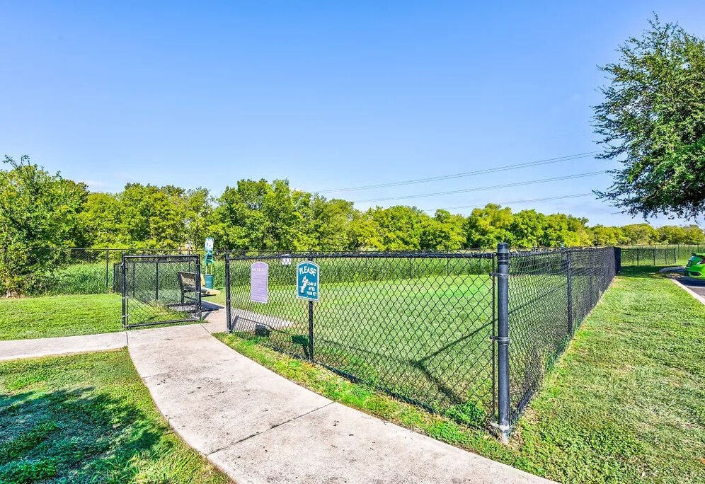 A park with a fence and a sign on it.