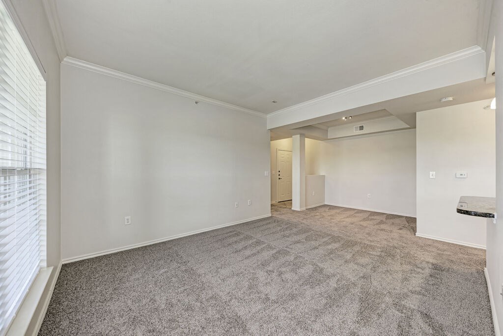 A spacious room with carpeted floor and white walls.