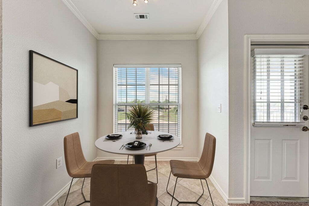 A dining room with a white table and chairs.
