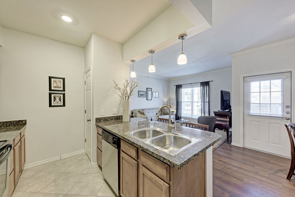 A kitchen with a sink, stove, and cabinets.