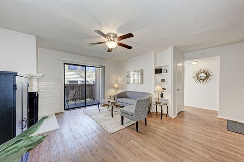 A living room with a grey couch and a ceiling fan.
