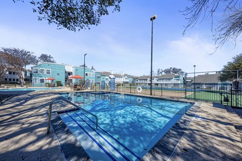 A blue swimming pool with a metal ladder on the left side.
