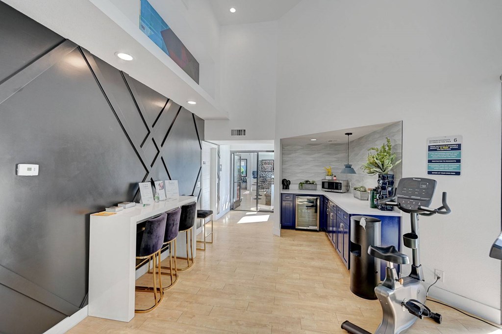 A gym with a treadmill, exercise bike, and weights.