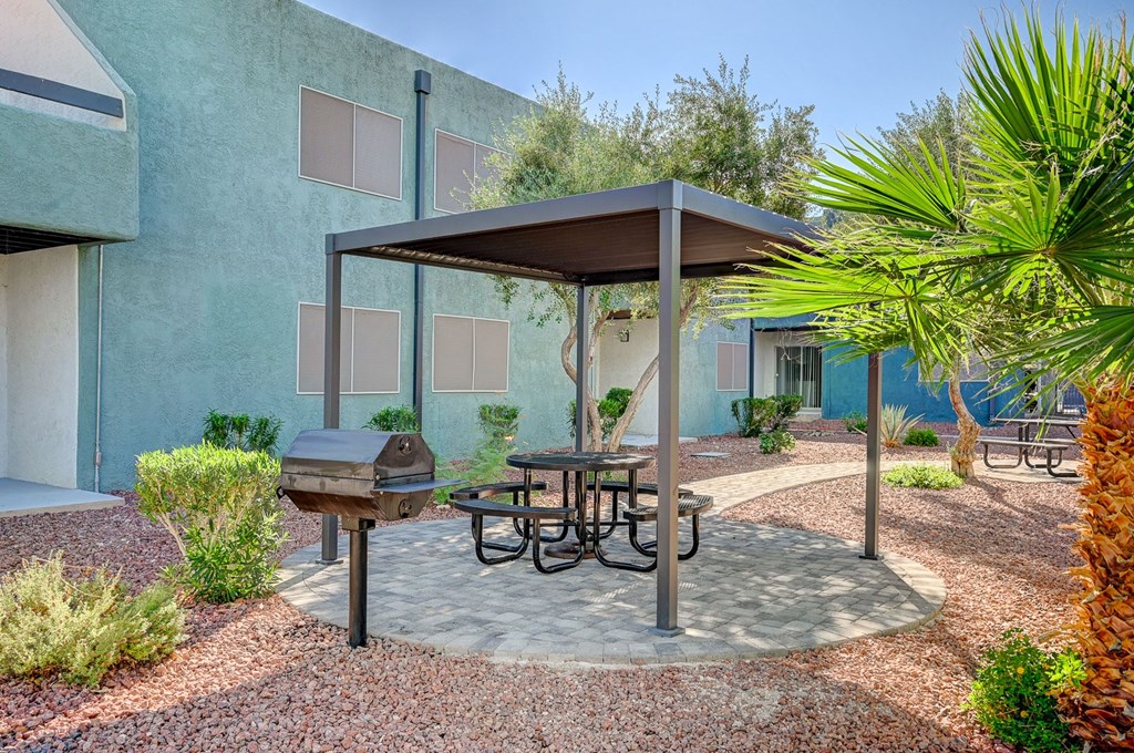 A patio with a table and chairs under a canopy.