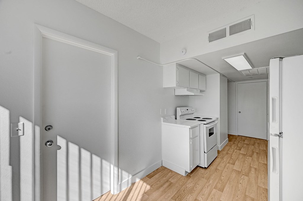 A small white kitchen with a stove and oven.