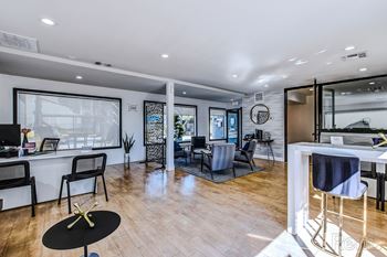 A modern living room with a black coffee table and a white dining table.