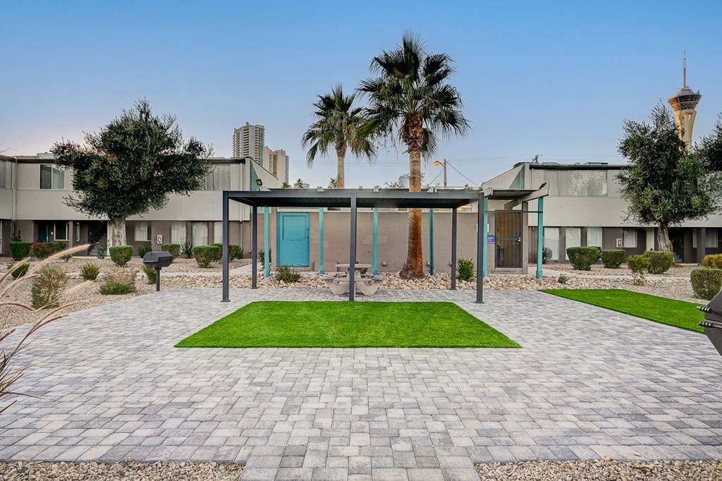 A building with a blue door is surrounded by palm trees.