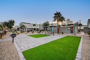 A modern building complex with a green lawn in front.