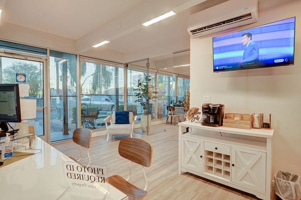 A modern office lobby with a reception desk and chairs.