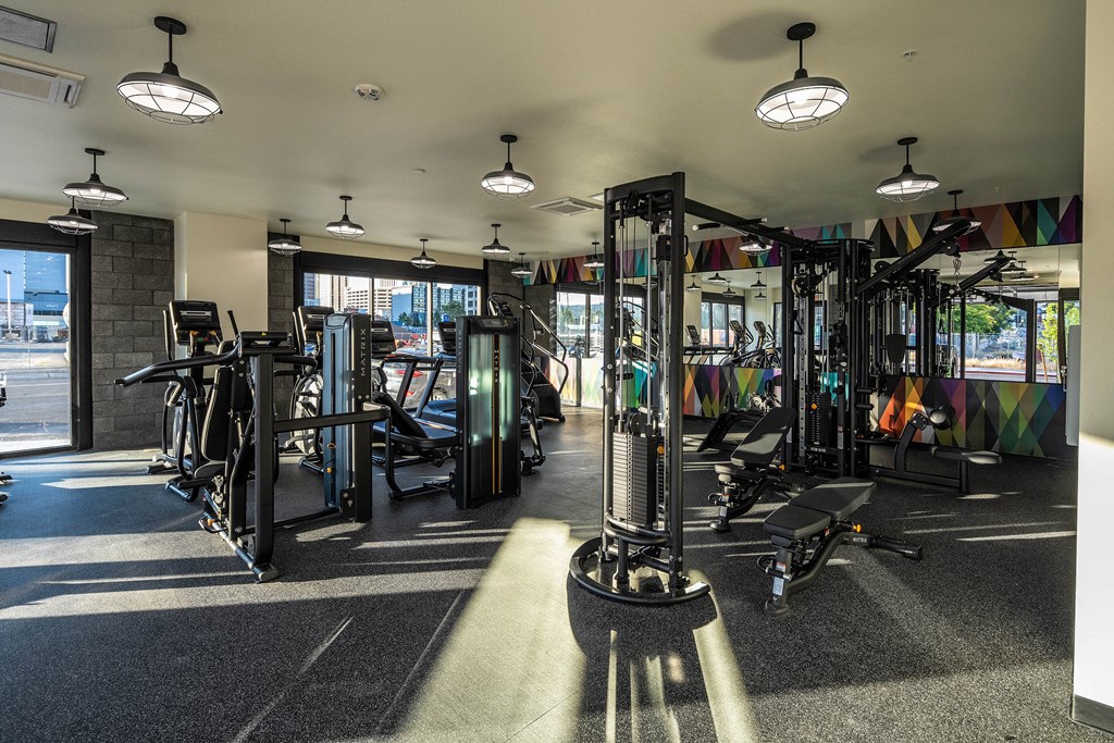 A gym with a variety of equipment including treadmills, weights, and exercise machines.