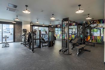 A gym with a variety of equipment including treadmills, weights, and exercise machines.