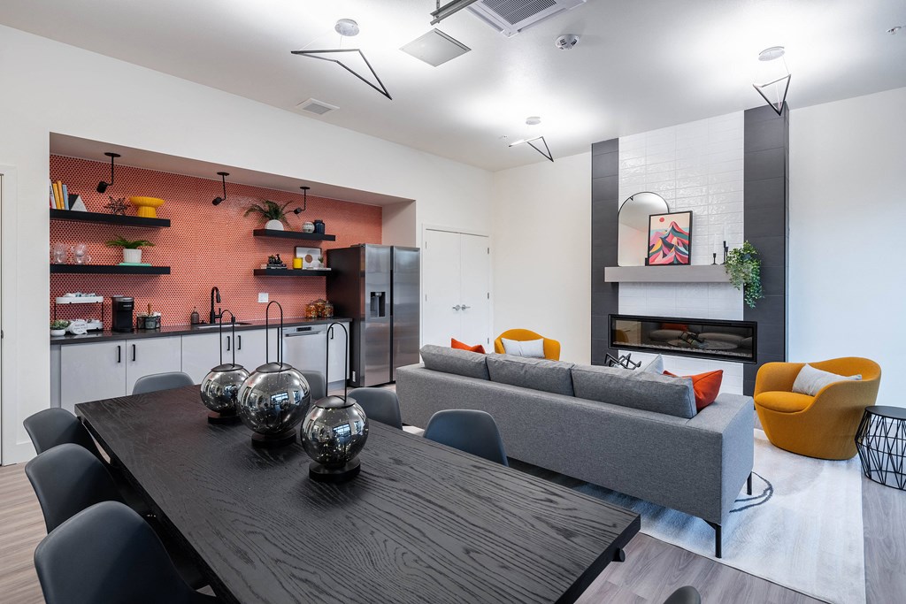 A modern dining room with a wooden table and grey couch.