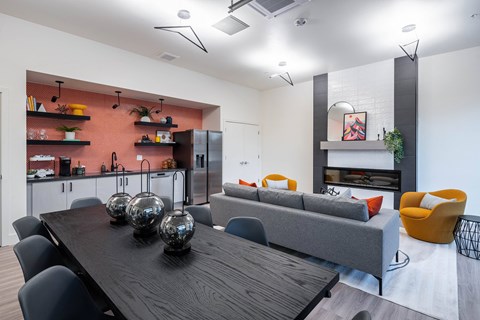 A modern dining room with a wooden table and grey couch.