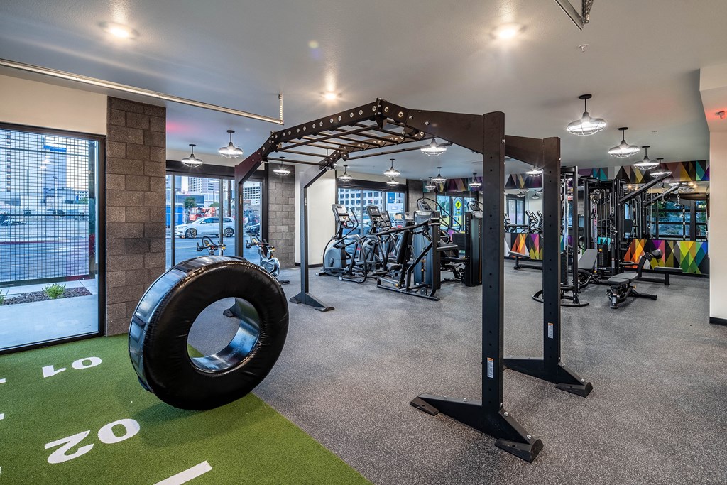 A gym with a green floor mat and a tire on it.