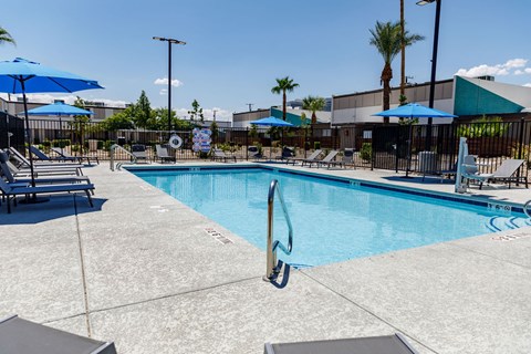 A pool with a diving board and sun loungers.