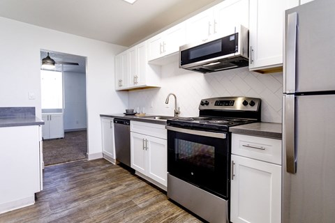 A kitchen with white cabinets and a black stove top oven.