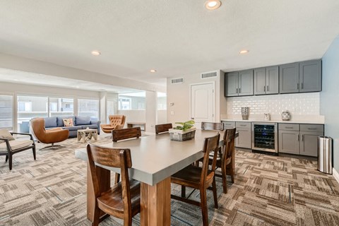 A kitchen with a dining table and chairs in the foreground.