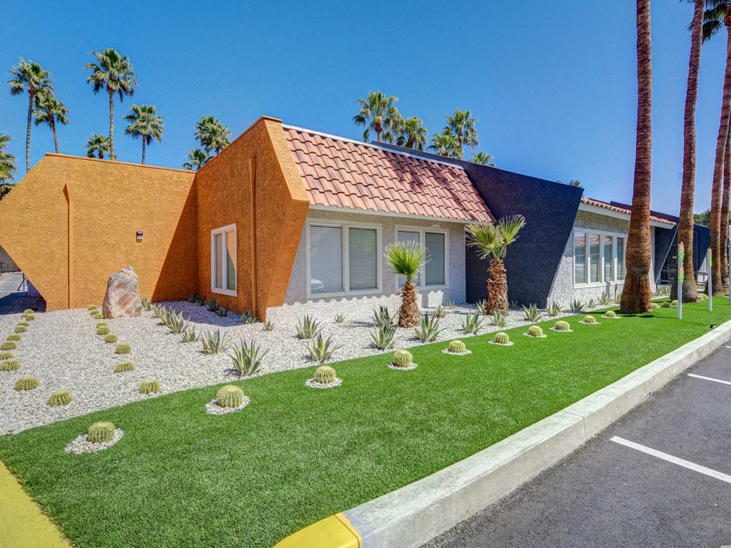 A house with a red tile roof and a yellow front yard.