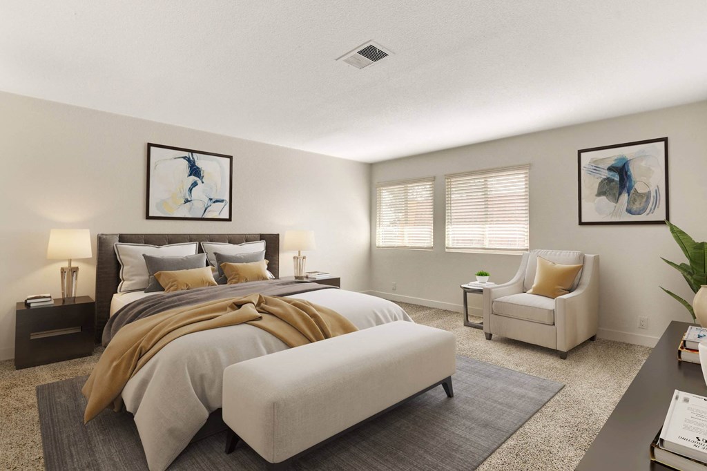 A bedroom with a large bed and a chair.