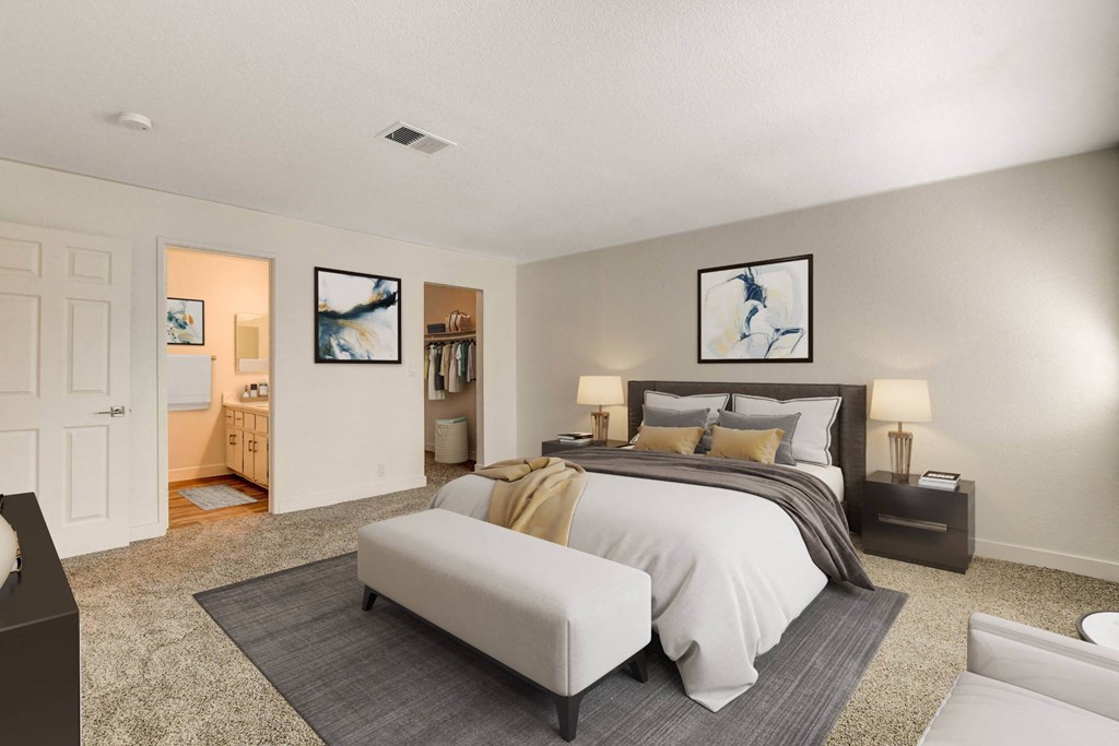 A bedroom with a large bed and a painting on the wall.