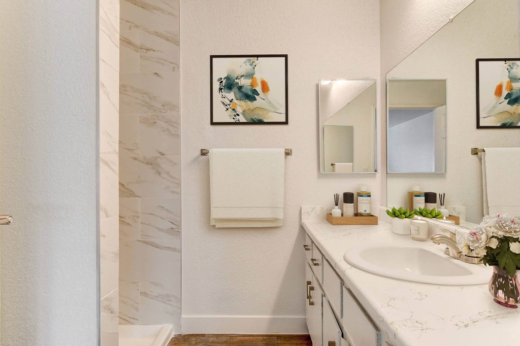 A bathroom with a marble wall and a white sink.