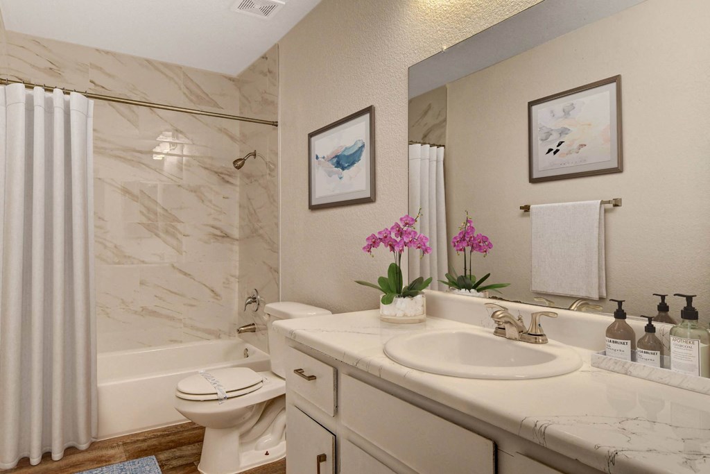 A bathroom with a toilet, sink, and a mirror.