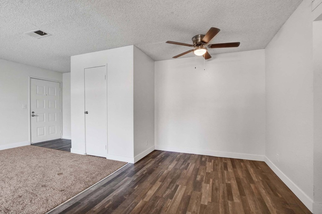 A room with a ceiling fan and two doors.