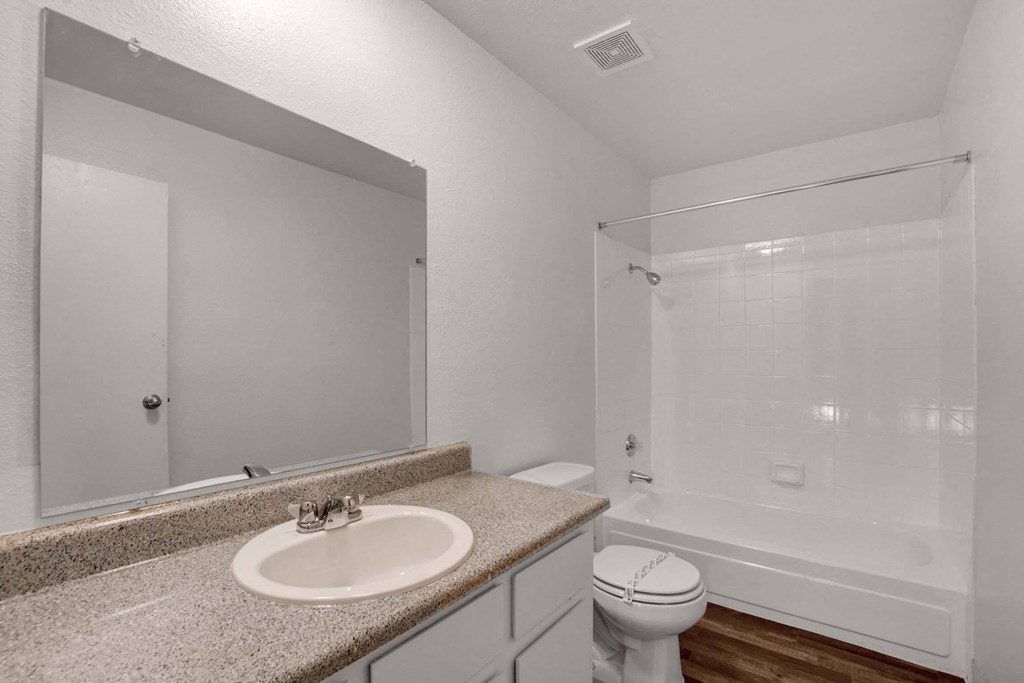 A bathroom with a sink, toilet, and bathtub.