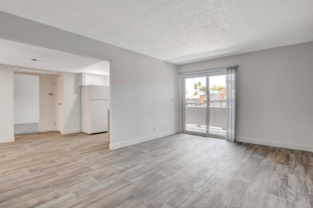 A room with a sliding glass door leading to a balcony.