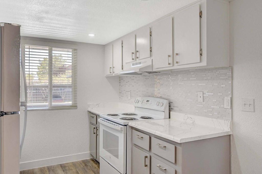 A kitchen with white appliances and cabinets.