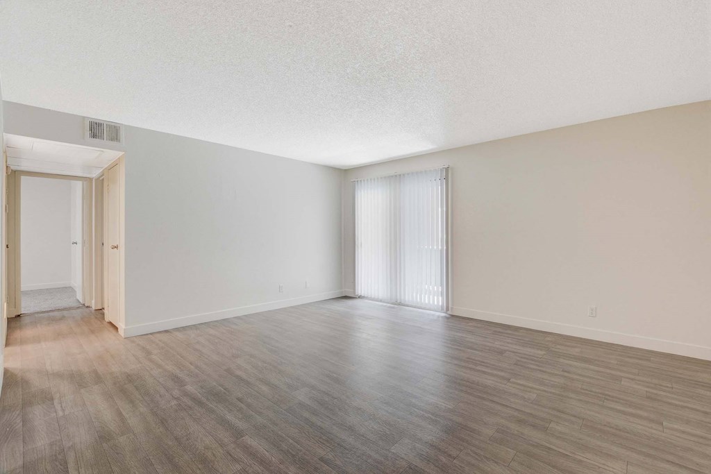 A room with wooden flooring and white walls.