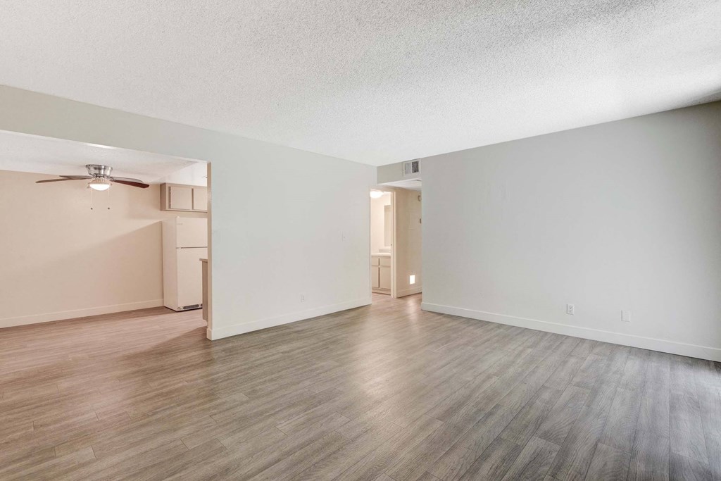 A room with a ceiling fan and a doorway leading to another room.