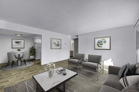 A living room with a grey couch, a coffee table, and a dining table set up.