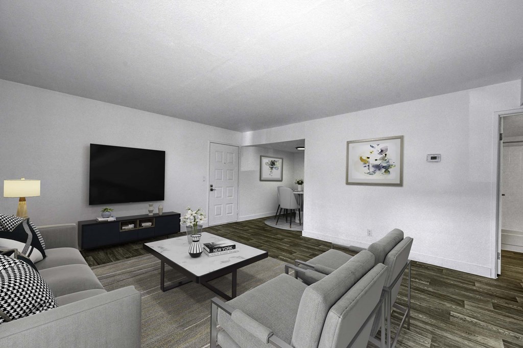 A living room with a grey couch, a black and white sofa, a coffee table, and a television.