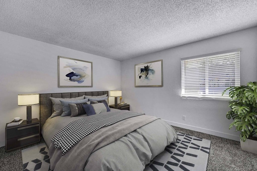 A bedroom with a large bed and a potted plant.
