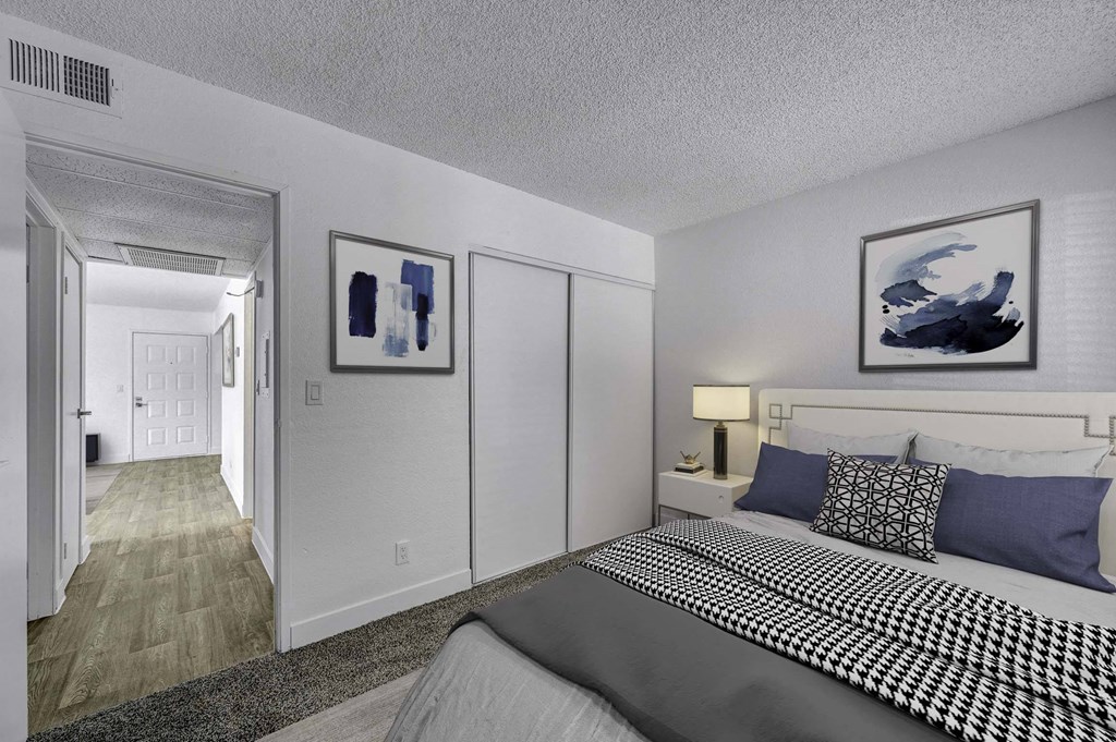 A bedroom with a large bed and two framed pictures on the wall.