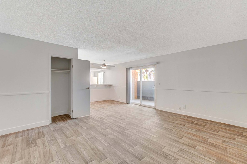 A room with wooden flooring and white walls.