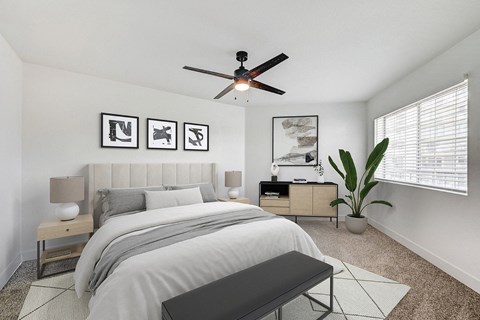 A bedroom with a bed, nightstands, and a ceiling fan.